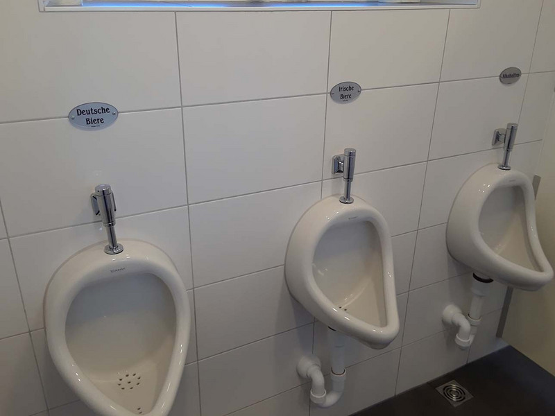 Pub's urinals labeled German Beer, Irish Beer, and Alcohol-free