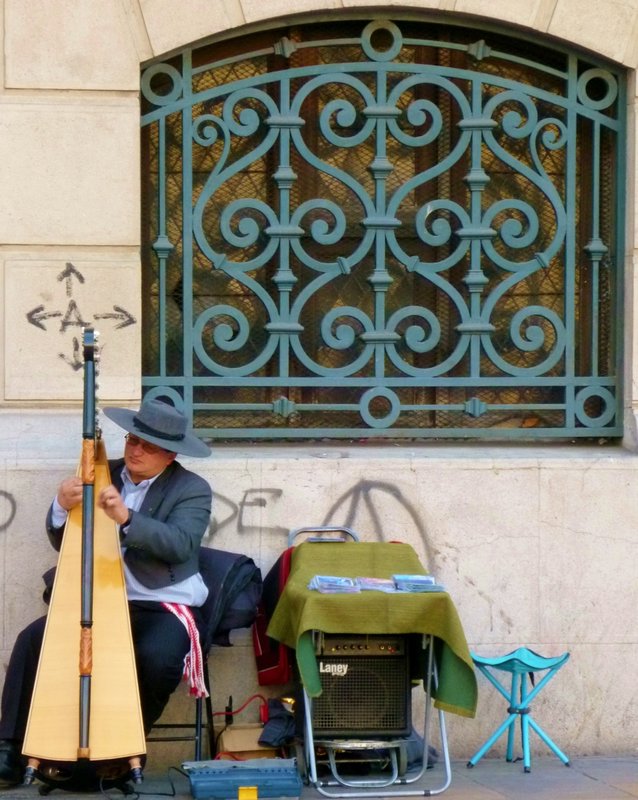 harpist serenading long line of people waiting for entrance to old boys' Union Clubon Dia de la Patrimonia