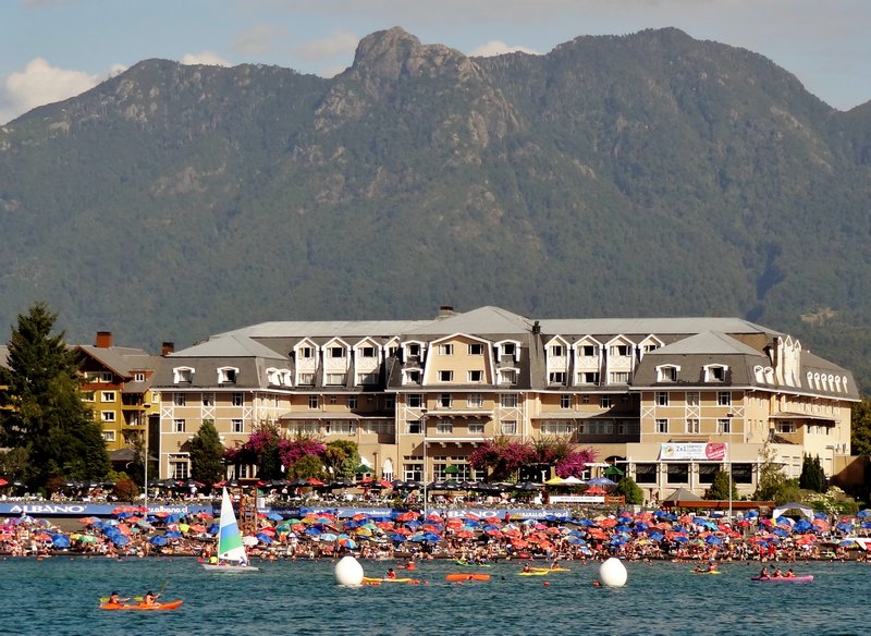 Classic Pucon--crowded summer beach in front of the Gran Hotel backed by protective mountains