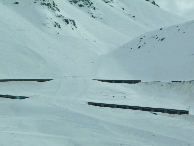  partially-buried tunnels with skiers crossing them