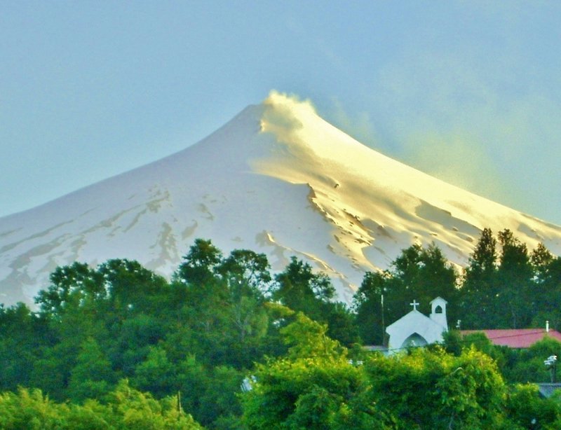 spring snow-covered volcano and convent