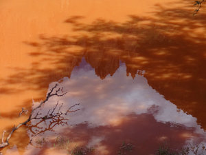 red puddle with slice of sky reflected