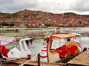 Puno peddle boats and the city rising on its hills