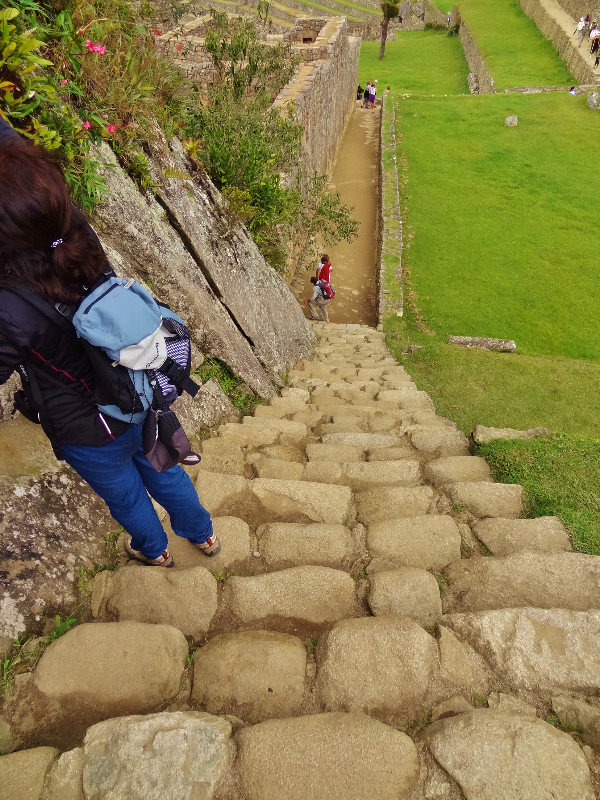 someone taking a vertigo break on steep stone stairs