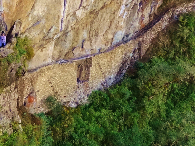 Incan log bridge along thin ledge of trail