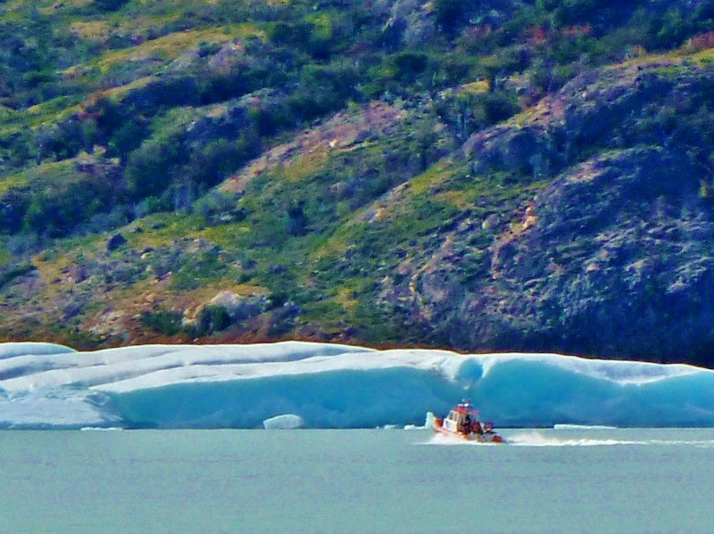 boat dwarfed by iceberg