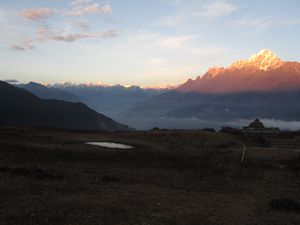 Sonnenuntergang, die Berge in weiter Ferne liegen in Tibet, die erste Doerfer waren zu sehen