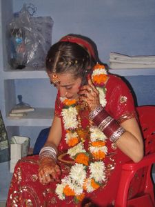 schon voll an Indien angepasst, die braut telefoniert waehrend der Maennerzerermonie bei der Hochzeit