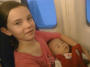 Baby Julia sleeping on Emma on the flight to Guangzhou
