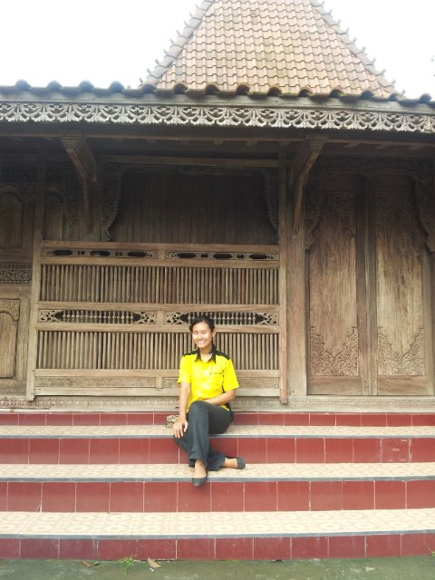 Dewi in front of a traditional Kudus home