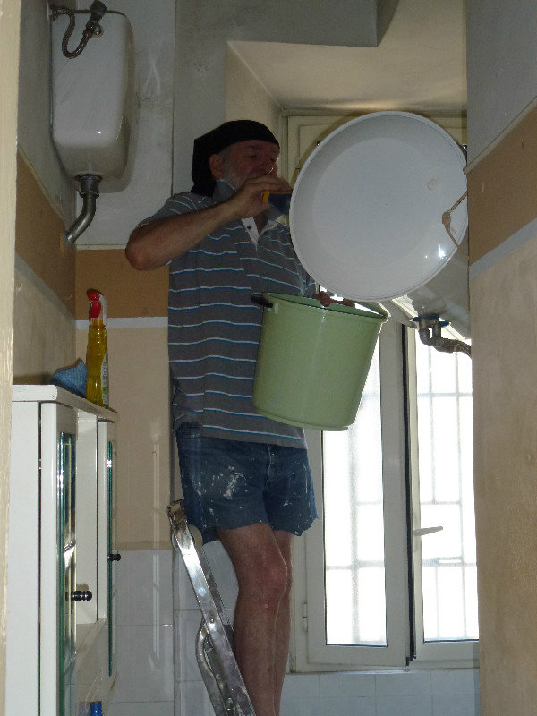 Dad bravely cleaning top of water heater