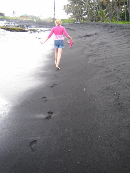 Footprints in the black sand beach