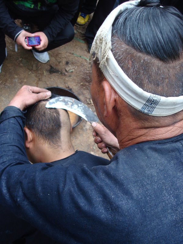 Basha - Shaving the mans head with a knife
