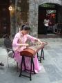 Lady playing traditional instrument