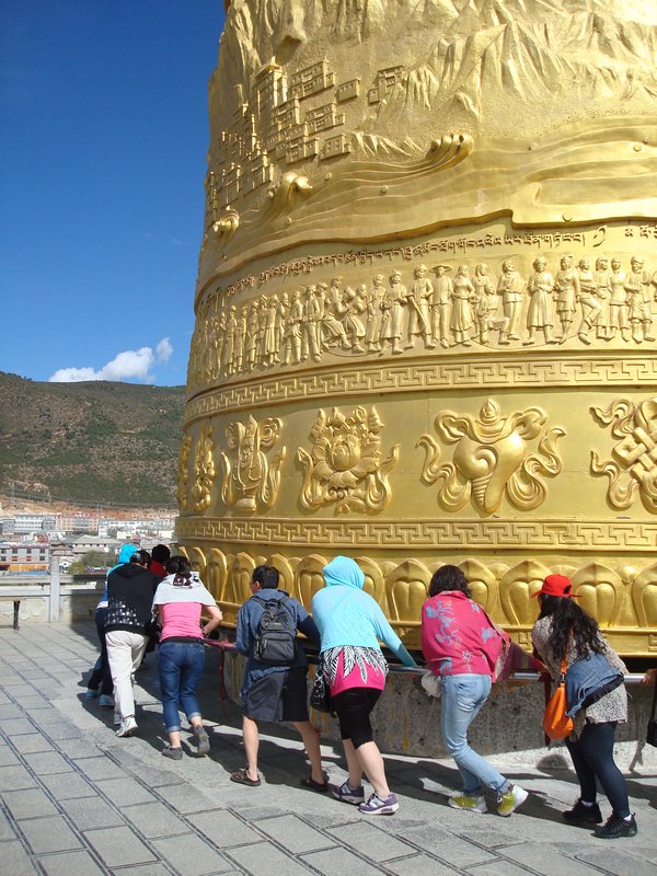 Shangri-La - Chinese tourists pushing a prayer wheel