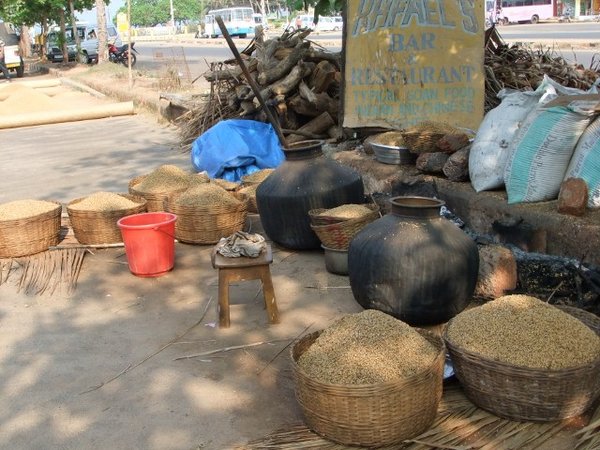 rice being cooked and dried on the roadside