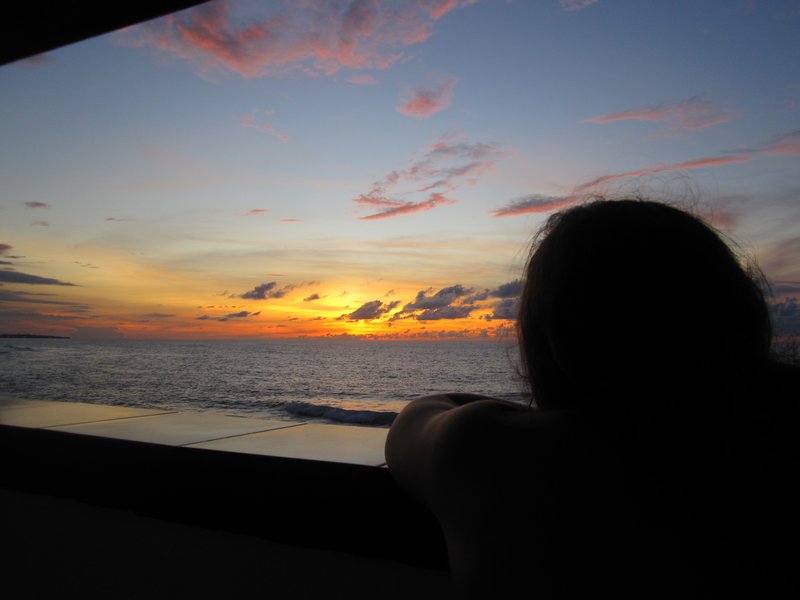 Audrey soaking up the sunset and cresting waves from our balcony