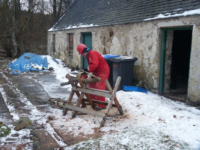 Gordon Snr cutting wood with chainsaw