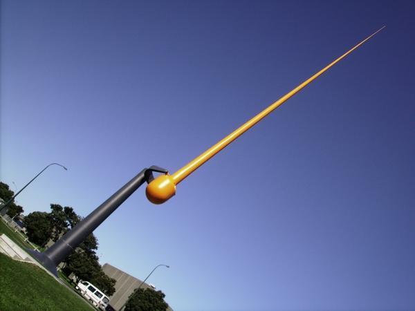 Giant wind operated orange needle-pendulum thing