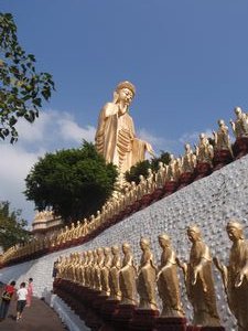 Amitabha Buddha and smaller statues lining the walkway 