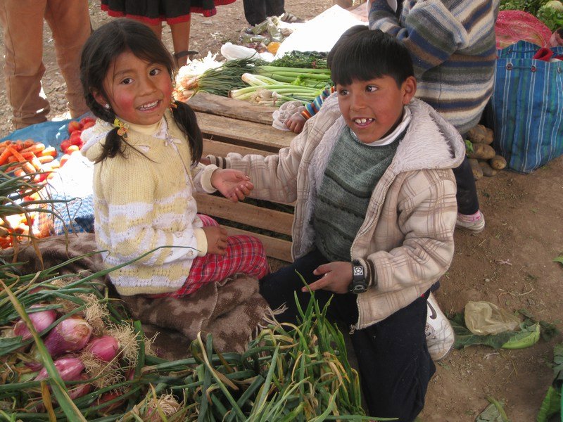 Local children play among the onions, Chinchero market