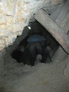 Crawling out of the mine, 40-50kg of ore strapped to his back