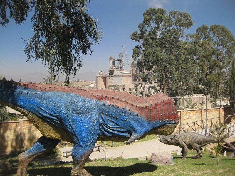 Giant model dinosaur posing in front of a cement factory...