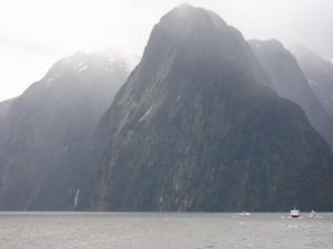 Boat dwarfed by the mountains at Milford Sound