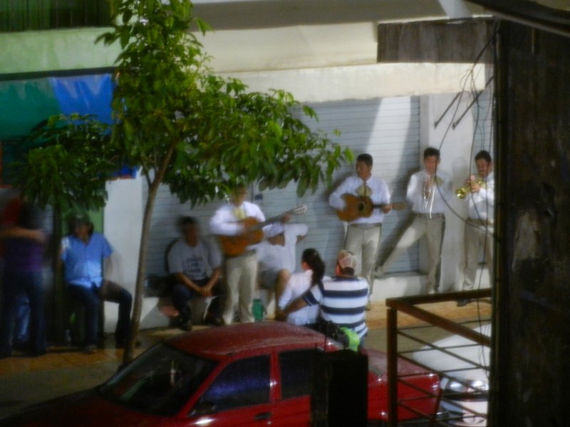 Mariachi band play on in the night rain