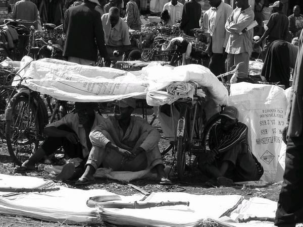 Men sheltering from the sun at the market