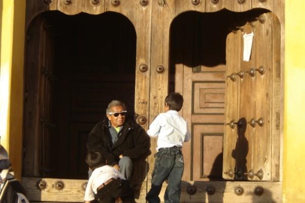 Old man and boy by doors of San Christobal church 