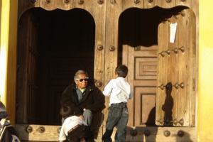 Old man and boy by doors of San Christobal church 