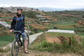 En sej Mathias på cykel foran en dal og kirkegård