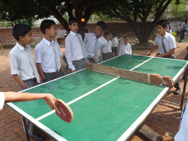 Boys playing table tennis in the school playground.