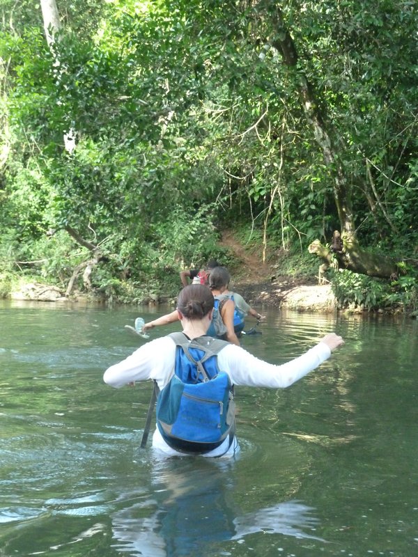 Wading through rivers to get to the cave via the jungle