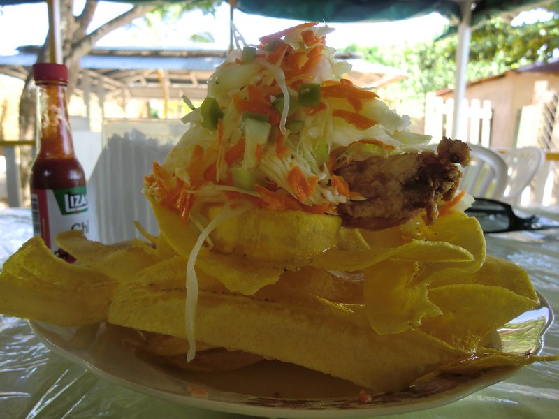Fried Chicken on a bed of plaintain chips topped with salad (coleslaw).