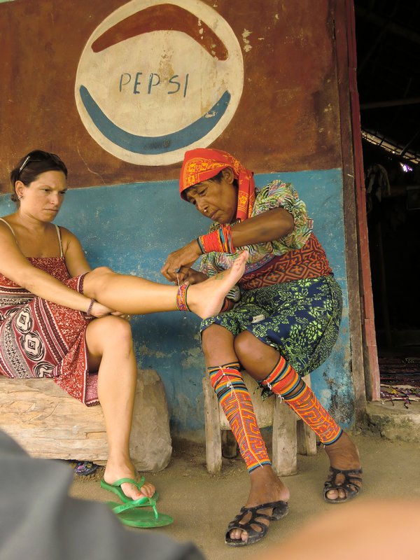 Delfina wrapping Kassandra's ankle in Kuna beads.