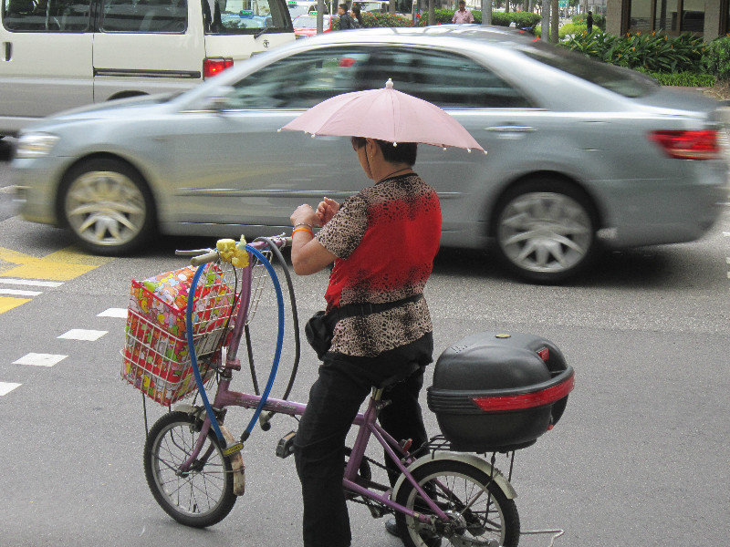 Many Singaporians use umbrellas to shelter from the sun