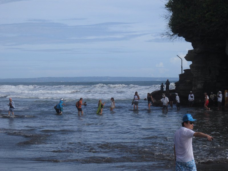 People walking across the water to the temple