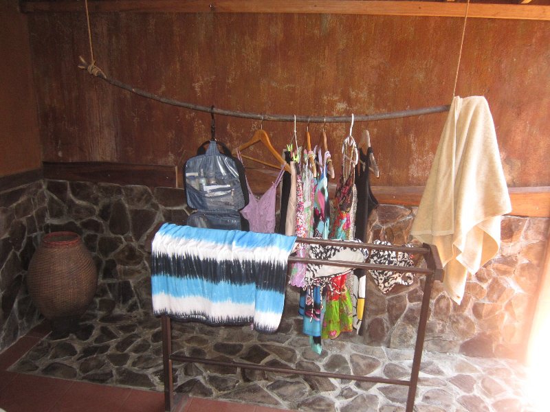 Our clothes hanging up on a tree branch in the bathroom