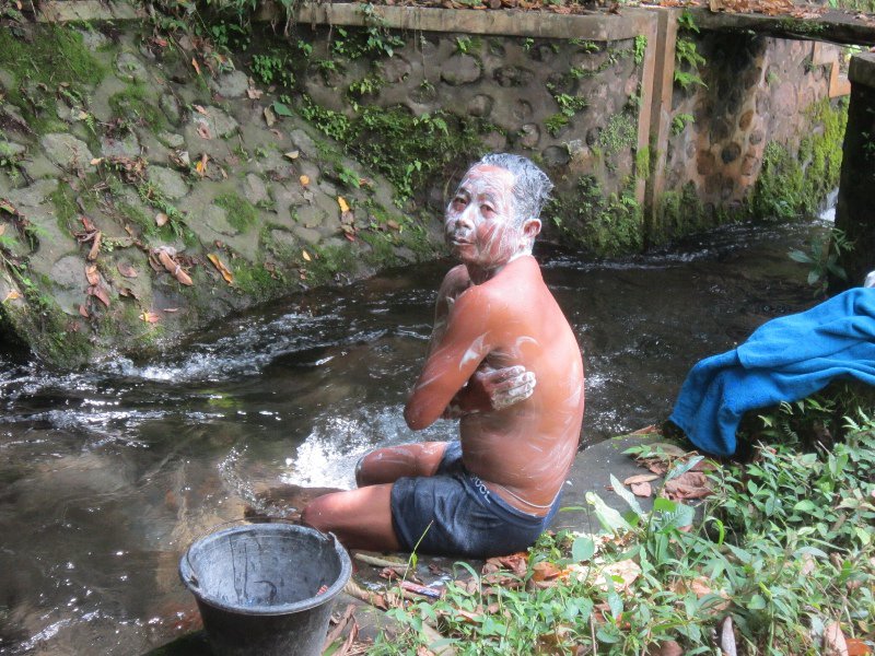 A guy on the path having a bath in the creek