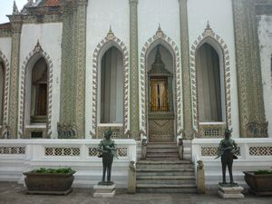 two statues in front of a building at Grand Palace Bangkok