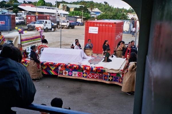 coffin being taken off the ferry and onto a decorated truck