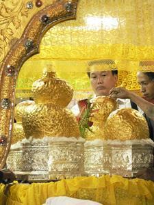 Applying gold leaves on the Buddha statues, so many that they are unrecognisable