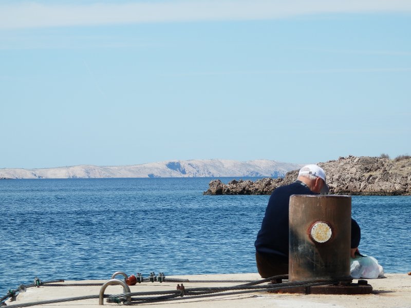 Old guy fishing at Pag ferry crossing