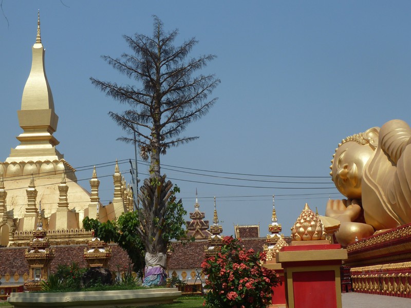 ThatLuang Stupa in Vientiane next to a reclining Buddha