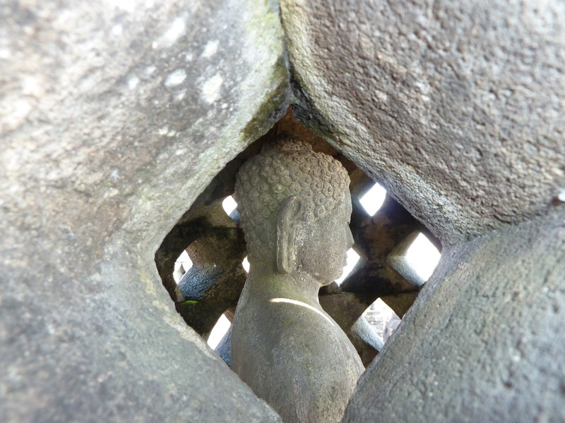 One of the few Buddhas with a head inside a Borobudur stupa