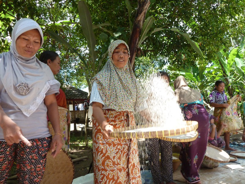 Local ladies cleaning rice donated to a grieving family