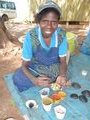 A Tiwi lady painting a shell for us