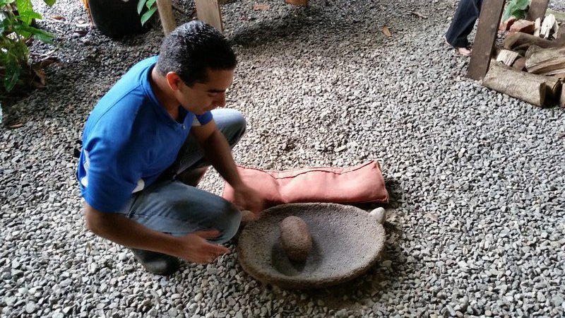 Op vulkaansteen worden de gepelde cacaobonen fijngemalen.